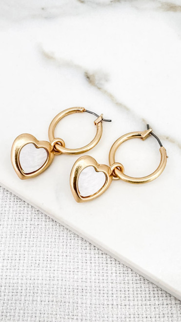 Gold hoop earring with a white heart dropper