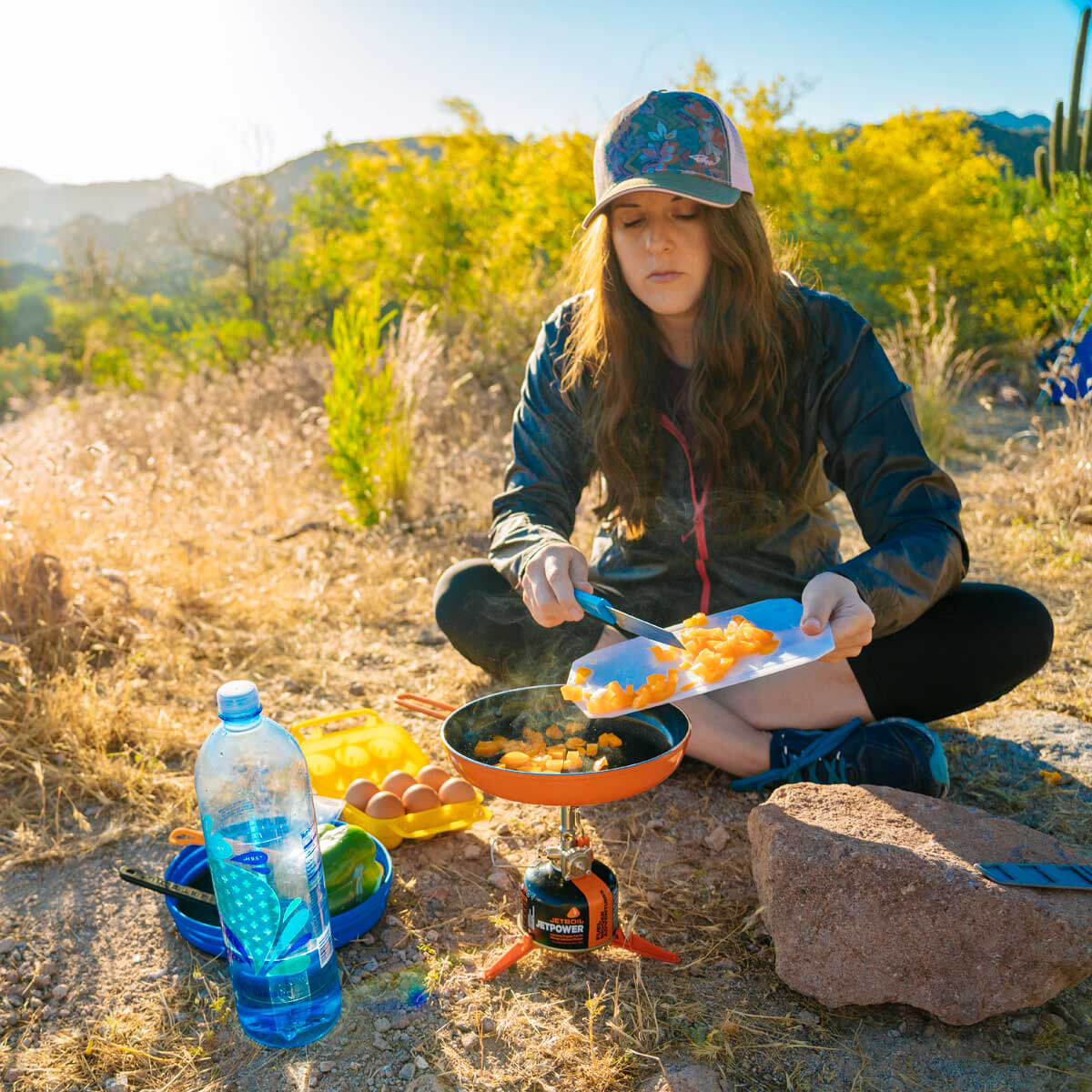 Woman using MightyMo to cook at camp.