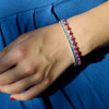 Oval Ruby and Baguette Diamond Bracelet in White Gold on model layered with blue sapphire bracelet