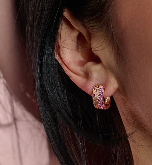 Pink Sapphire Huggie Earrings in Rose Gold on ear