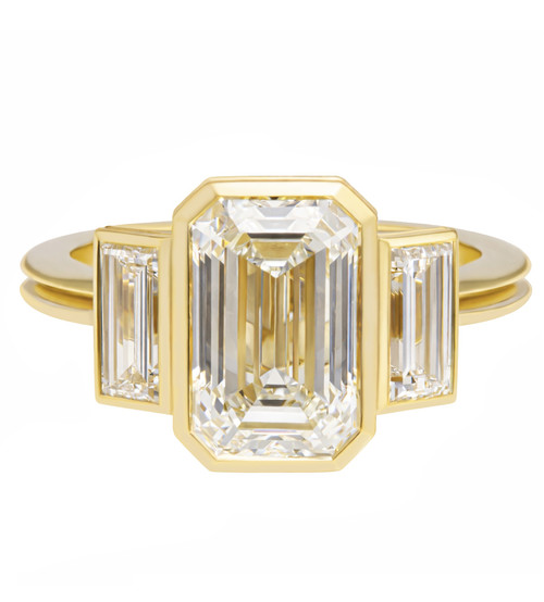 Three stone emerald cut bezel set engagement ring in yellow gold
