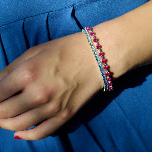 Oval Ruby and Baguette Diamond Bracelet in White Gold on model layered with blue sapphire bracelet