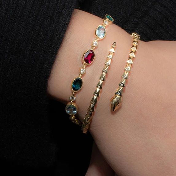 Multi tourmaline bracelet and gold snake bracelet on wrist 