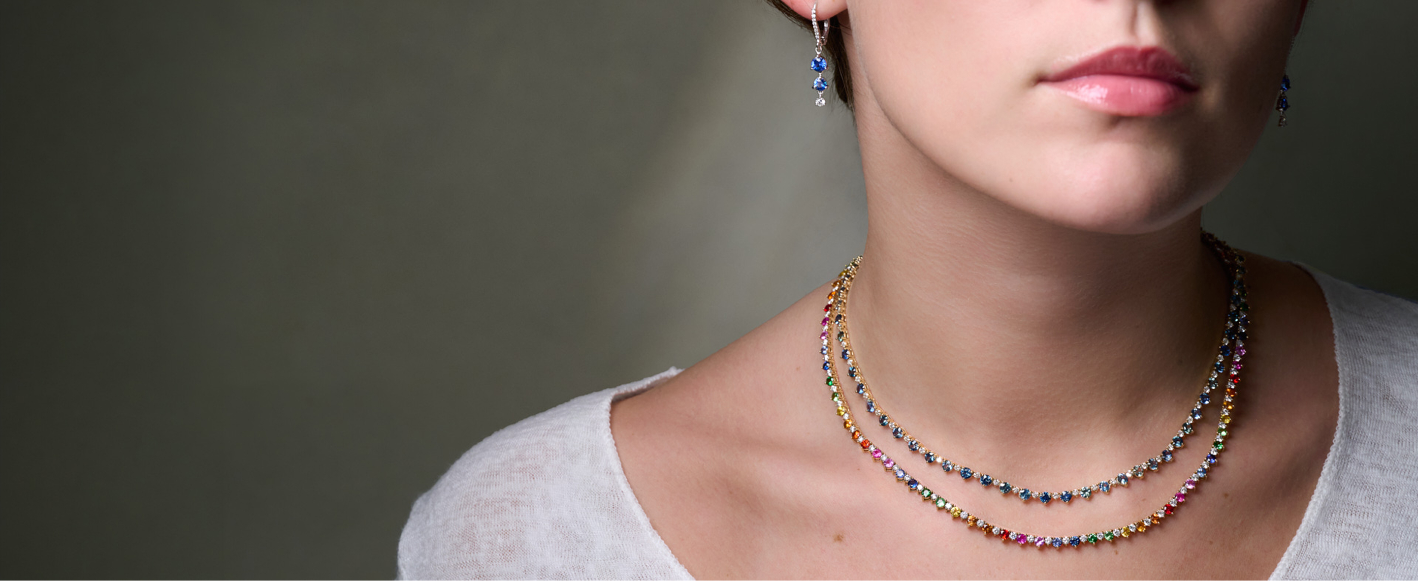 Multi-sapphire and diamond tennis necklaces and sapphire earrings on model 