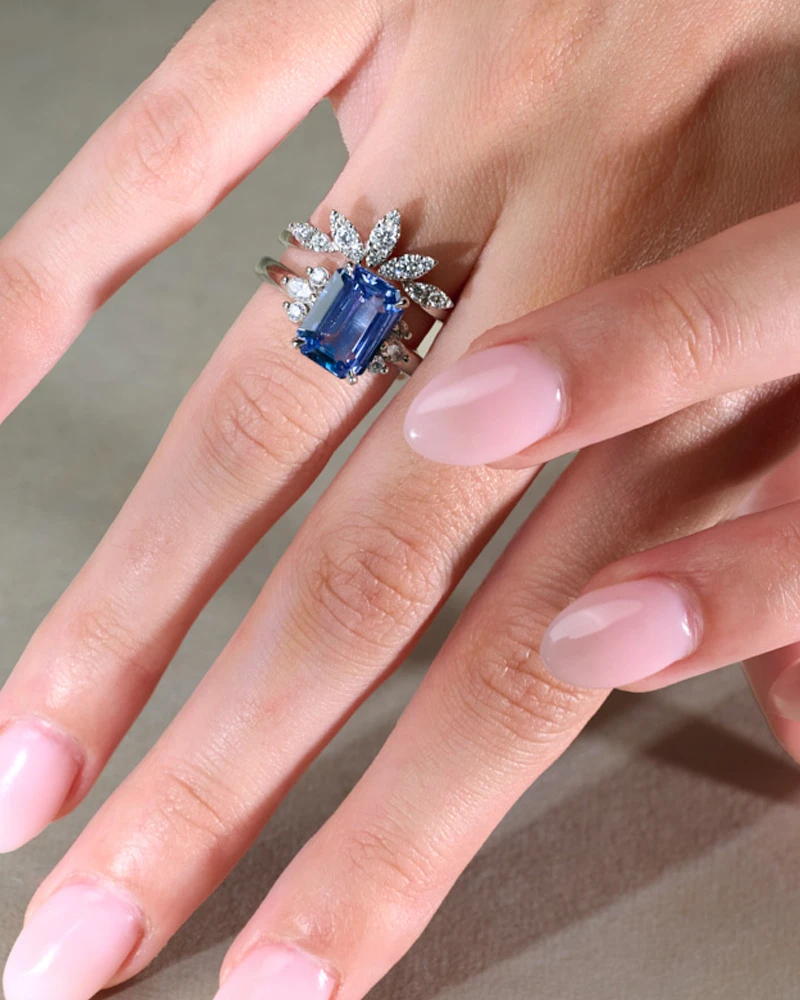 sapphire and diamond engagement rings with wedding bands on hand model 