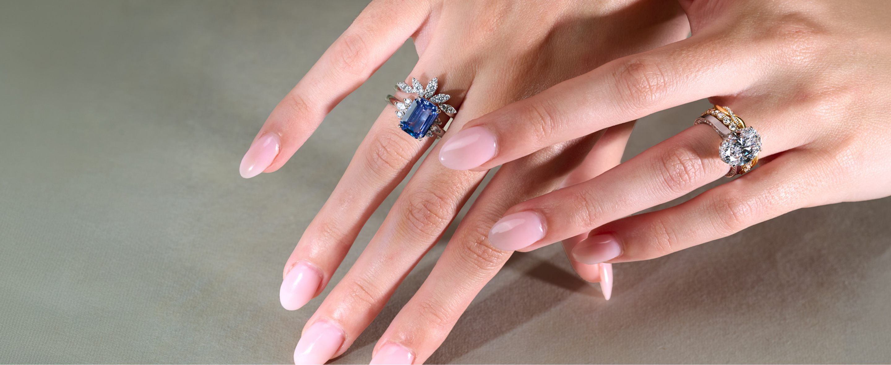 Sapphire and diamond engagement rings with wedding bands on hands 