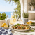 Fresh summer cooking scene with grilled vegetables, lemonade, lemons, herbs, and Mediterranean flavors for custom spice gift box inspiration.