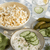 Dill pickle popcorn with cottage cheese, cucumber slices, fresh dill, pickles, and a refreshing cucumber drink for a salty snack idea.