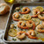 Garlic butter shrimp with lemon slices, thyme, olive oil, roasted garlic, and rustic lemon garlic herb seasoning flavor.