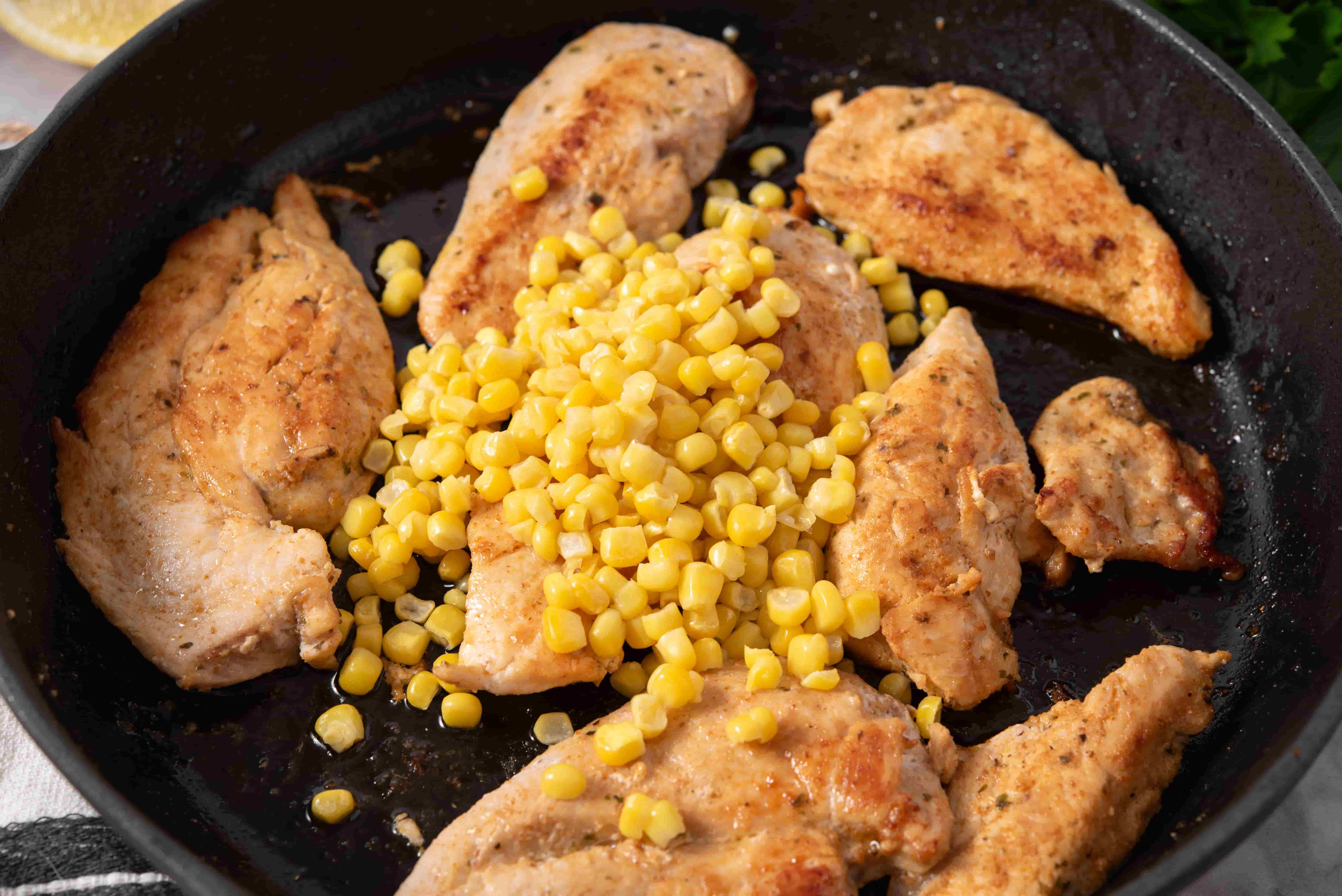 BBQ seasoned chicken cooking in a skillet with sweet corn for BBQ Chicken Tortilla Folds