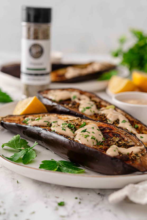 Roasted Italian Eggplant with Lemon Tahini Sauce served with parsley, lemon wedges, and Milford Spice Company Salt Free Italian in the background