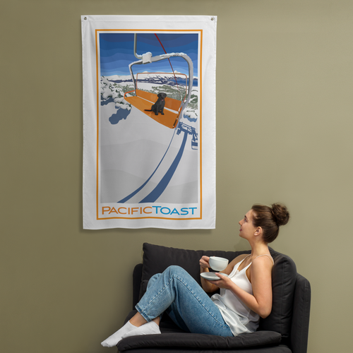 A sitting woman drinks coffee while admiring a wall banner illustrated with a cute, back Labrador puppy on a ski chair lift