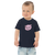 Toddler in navy blue t-shirt featuring an original illustration of a pig