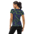 Woman in navy blue athletic t-shirt featuring bright green abstract print (back view)