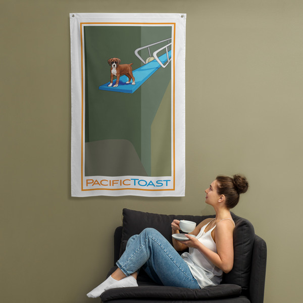 A sitting woman drinks coffee while admiring a wall banner illustrated with a cute boxer puppy on a diving board