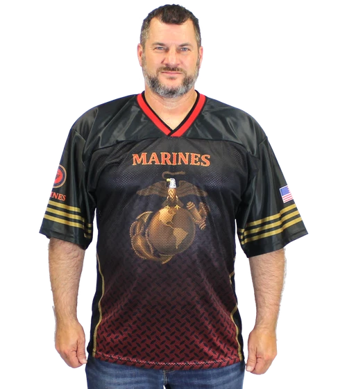 Human model wearing U.S. Marines Sublimated Football Jersey featuring bold USMC graphics, breathable athletic fit, and short-sleeve performance design.