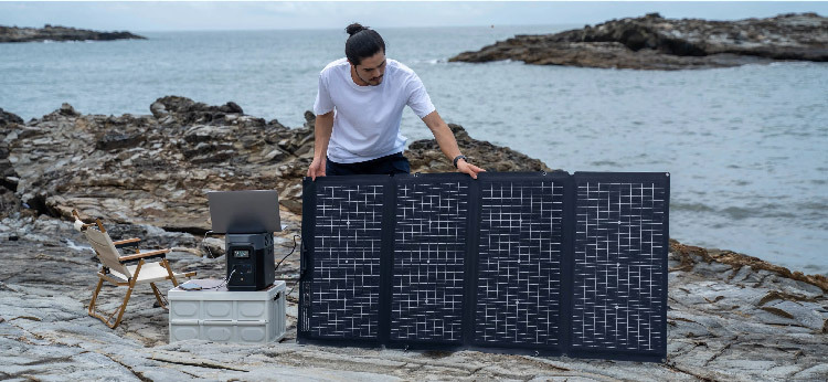 Man setting up solar panels on a rocky beach