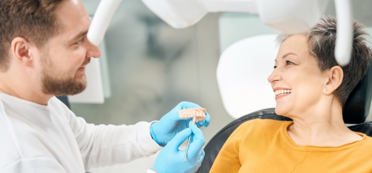 Dentist examining a patient's mouth whilst she smiles