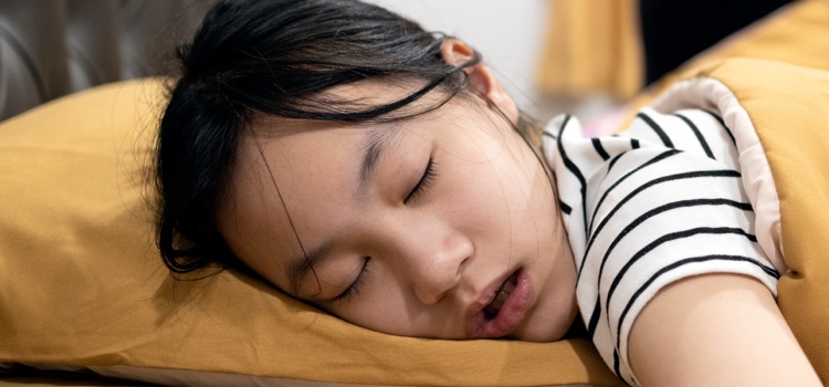 Young girl sleeping and drooling with mouth open.
