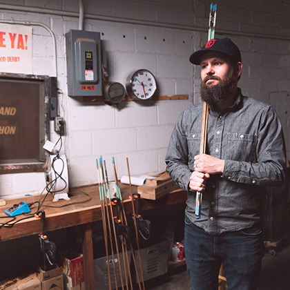 Bearded man holding alignment sticks over his shoulder