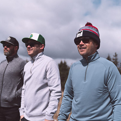 Three men wearing jackets and caps