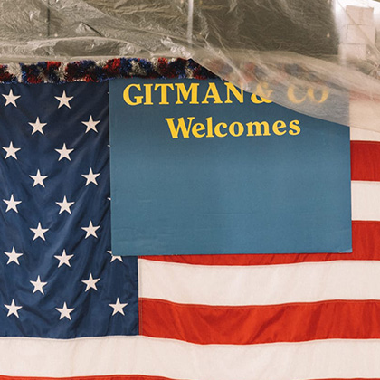 Gitman and Co sign n front of American flag