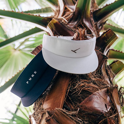 Imperial Headwear visors on a palm tree