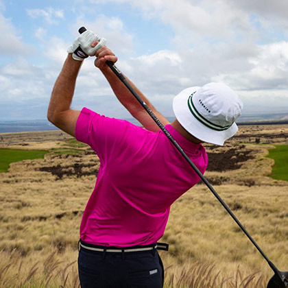 Man wearing Imperial Headwear cap swinging golf club