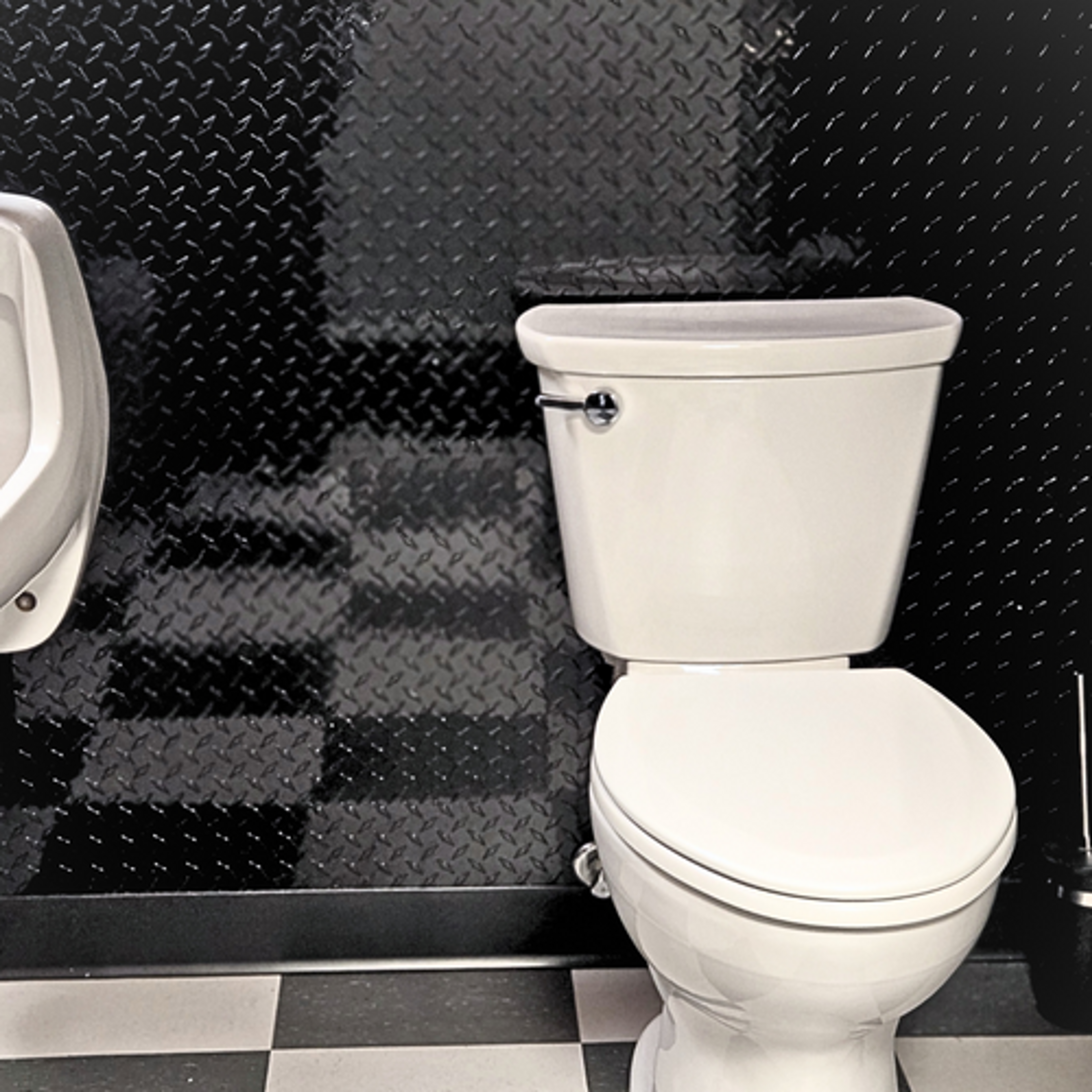 Mancave bathroom with checkered floors and clack diamond plate on the walls for a manly industrial feel.