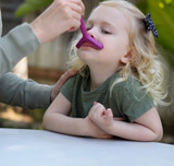 A therapist uses the magenta Y Tip with a young client to work on lip closure