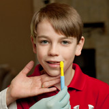 A therapist uses the Preefer Tip with a young client for tongue lateralization