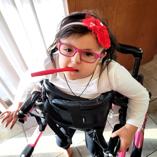 A child chews on the red Textured Bite Tube, a hollow chew and great option for sensory seekers who need extra input from texture