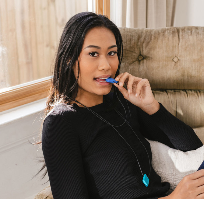 An adult chews a Teardrop necklace; a small, thin shape perfect for discreet chewing