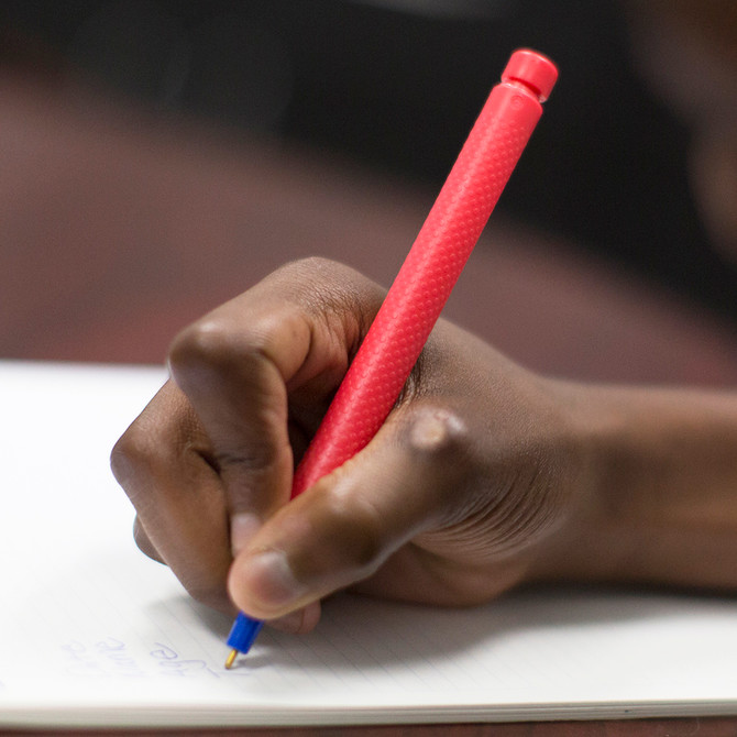 A hand writes using the Tran-Quill Pen. "Wake up" the hand with sensory input