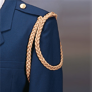 Gold braided double circle shoulder cord on navy blue uniform. Gold braided double circle shoulder cord on navy blue uniform.