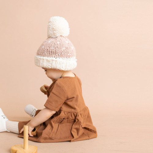 The Shiloh Pom Hat in Blush by The Blueberry Hill is the ideal blend of style and warmth, designed for young fashionistas aged 2-5 years.