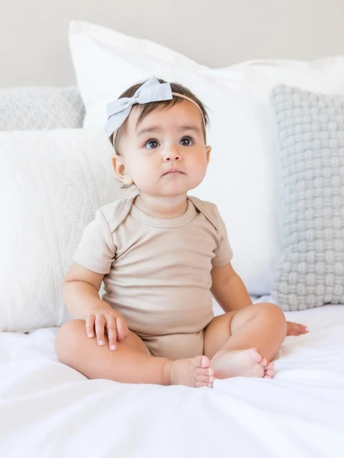 Wrap your little one in the purest comfort with the Long Sleeve Bodysuit in Clay from Colored Organics. C