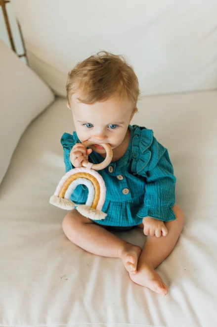 Introduce gentle relief to your little one's teething journey with the Chewable Charm Macrame Rainbow - Light Pink + Baby Blue.