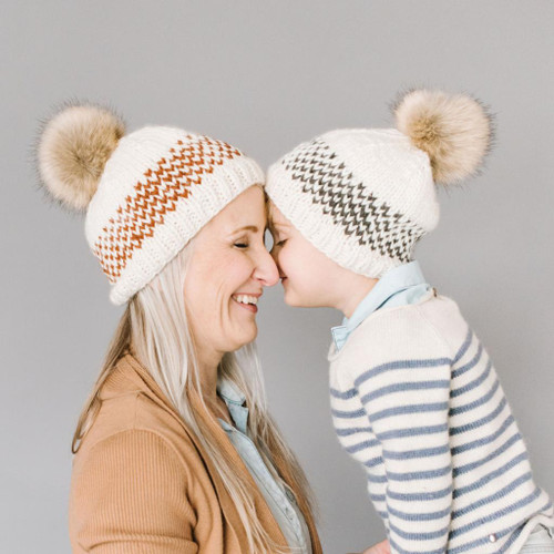 Stay warm and fashionable with the Fair Isle Stripe Beanie Hat with Fur Pom in Cinnamon.