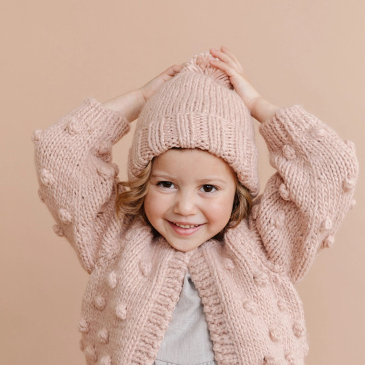The playful pink pom beanie adds a touch of fun and whimsy to your look. Whether you're hitting the slopes, strolling through the park.