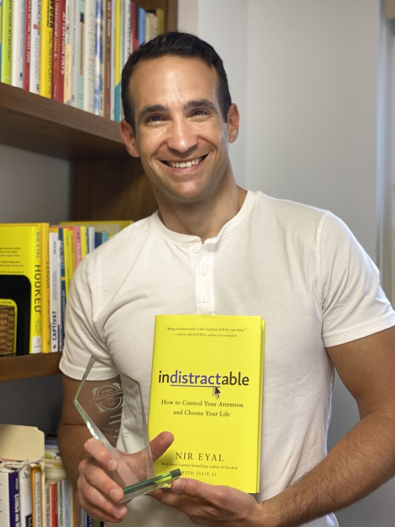 Nir Eyal, author of Indistractable, with his book and 2020 OWL Award