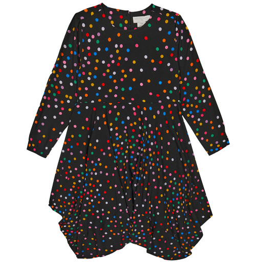 Girl twirling in Stella Kids’ multicolored polka dot dress with an asymmetric skirt.