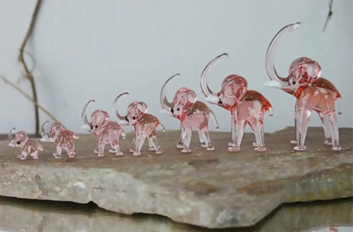 A set of 7 colorful glass elephants, each showcasing intricate craftsmanship and vibrant hues.