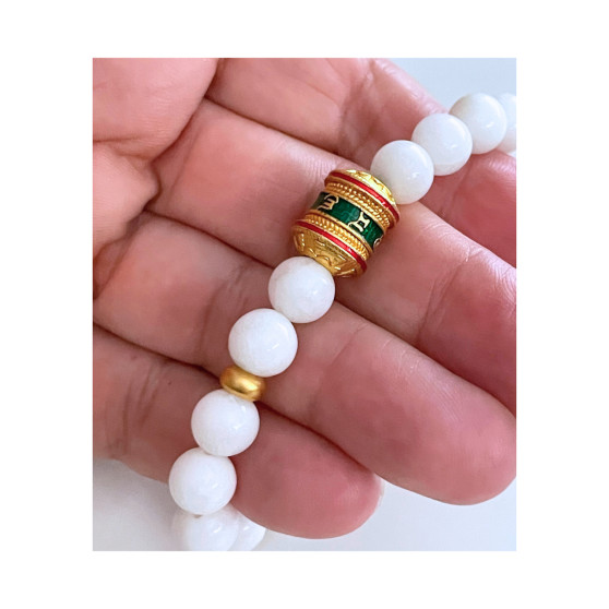 White jade bead bracelet featuring sand gold bead with inscribed mantra Om Mani Padme Hum