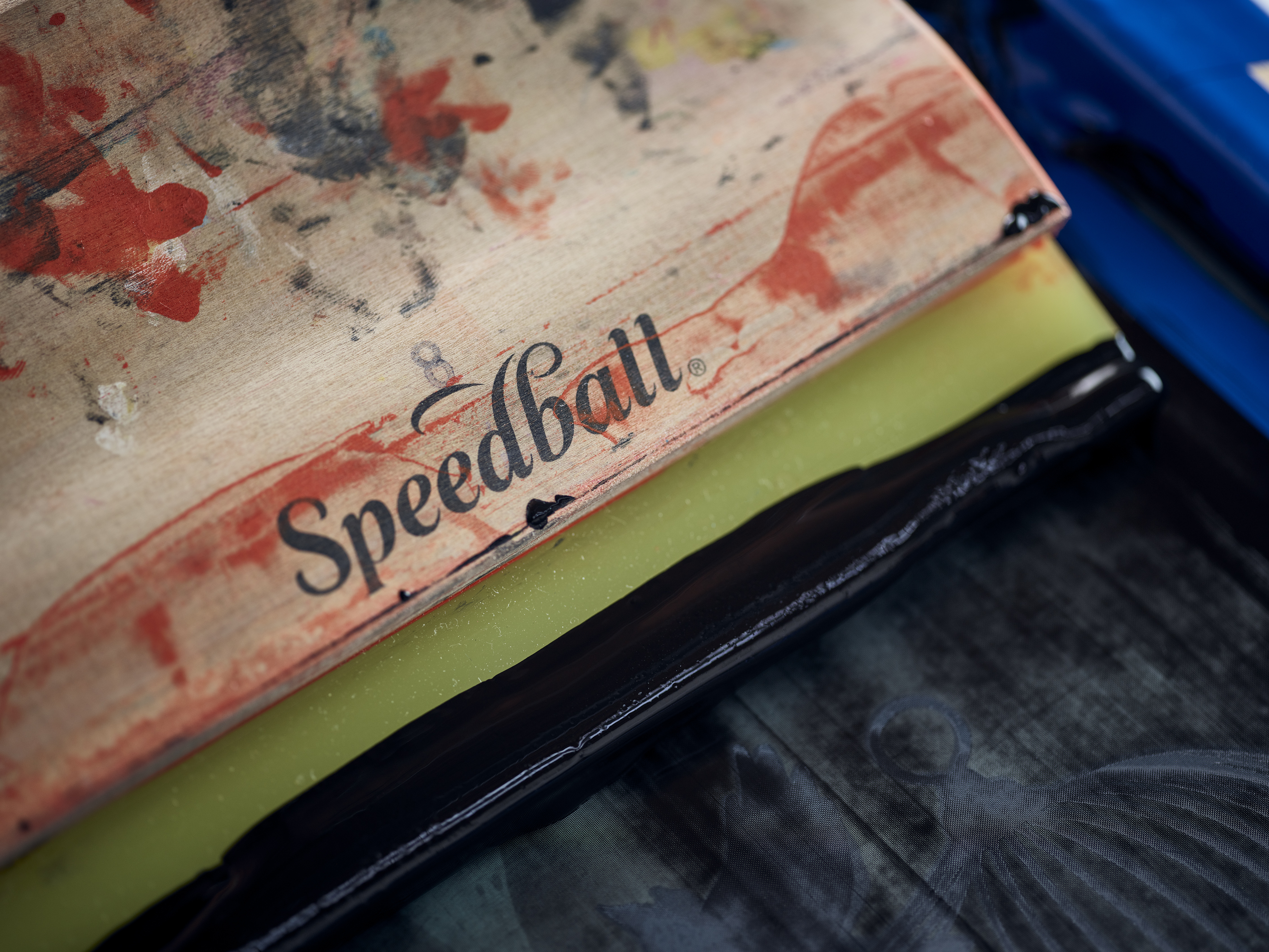 Close-up of screen printing frame and squeegee with black ink