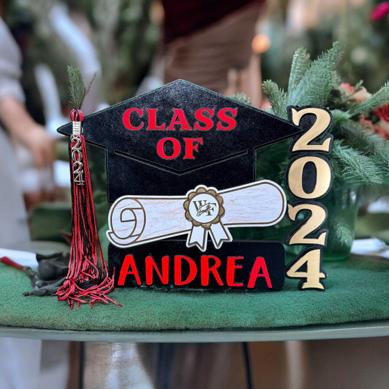 Personalized graduation cap-shaped plaque with the year '2024' and your name in bold letters, featuring a magnetic red tassel and a detailed diploma with school mascot.