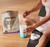 Women scooping protein + collagen powder into shaker