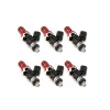 Set of six ID1050X fuel injectors, angled view showing red top hats, black bodies and lower Denso connectors.