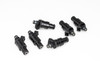 Set of six DeatschWerks 1200cc low impedance fuel injectors, black bodies with fittings, arranged on white background.