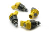 Set of four DeatschWerks 950cc side feed fuel injectors for Nissan SR20, arranged in circle showing yellow tops and nozzles